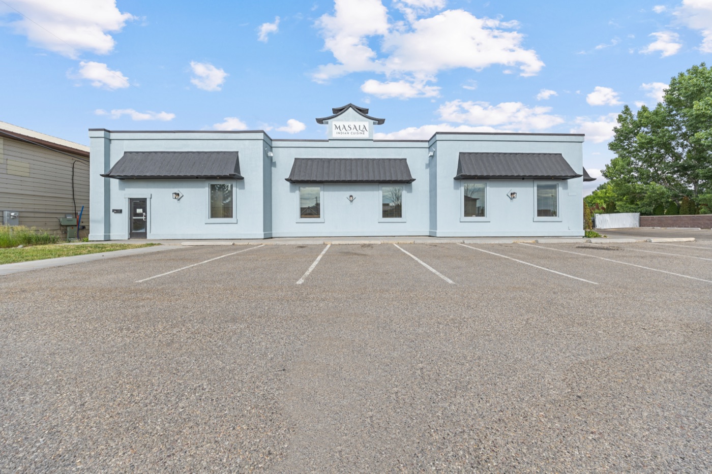 Building exterior with 26-space parking lot, daytime view from 2nd West